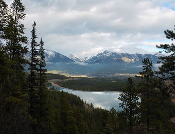 Scenic view of mountains and lake against cloudy sky