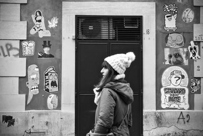 Side view of woman standing by window