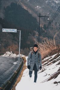 Full length of man standing on road during winter