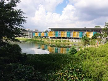 Scenic view of lake by buildings against sky