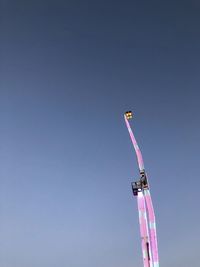 Low angle view of flags against clear blue sky