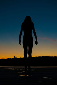Silhouette man standing against clear sky during sunset