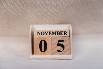 Close-up of information sign on table against wall