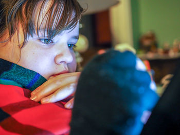 Close-up of girl using mobile phone at home