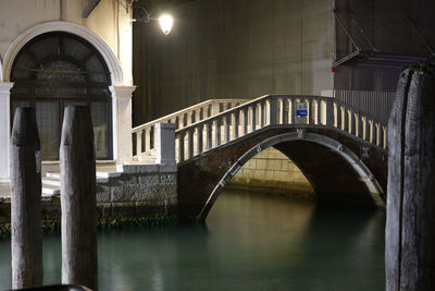 Arch bridge over river at night