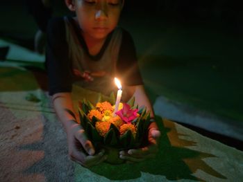 Midsection of girl holding illuminated flower