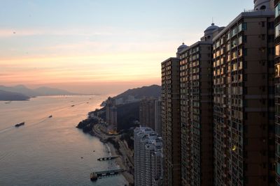 View of city at waterfront during sunset