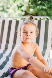 Portrait of shirtless boy sitting outdoors