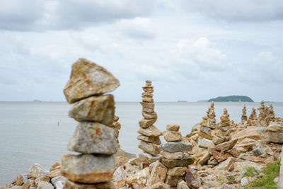 Stack of rocks on shore against sky