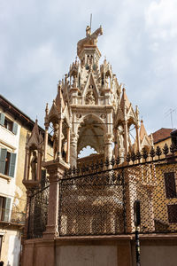 Low angle view of statue of historic building against sky