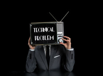 Man using smart phone against black background