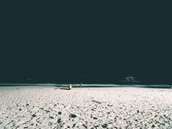 Scenic view of beach against clear sky at night