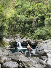 Rear view of man standing in waterfall