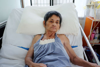Senior woman relaxing on bed at hospital