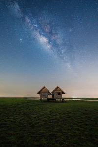 House on field against sky at night