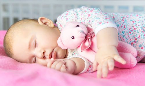 Portrait of cute baby boy lying on bed at home