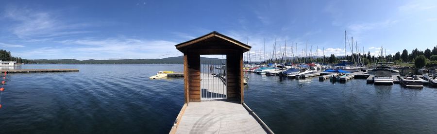 Sailboats moored in sea against sky