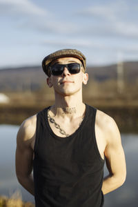 Close-up portrait of young man wearing sunglasses and hat on sunny day