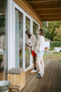 Happy couple talking to each other while entering in house