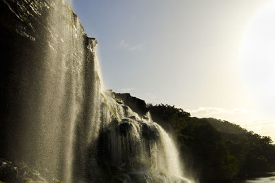 Scenic view of waterfall against sky