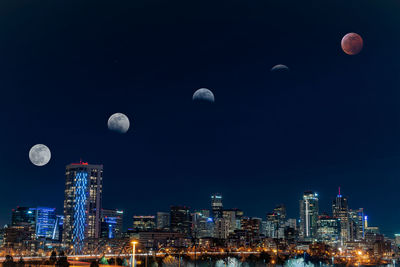 Full moon in city against sky at night