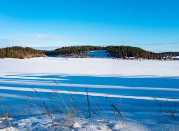 Scenic view of snowcapped landscape against blue sky