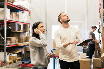 Man and woman examining boxes at distribution warehouse