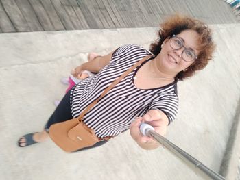 High angle portrait of smiling woman lying on floor