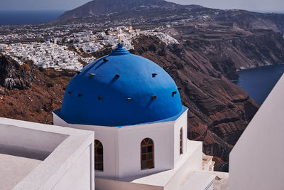 Anastasis church with its blue dome and tower in imerovigli village, santorini, greece