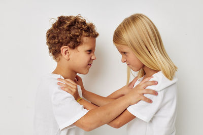 Siblings fighting against white background