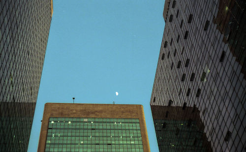 Low angle view of modern building against clear blue sky