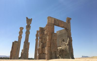 Low angle view of old ruins against blue sky