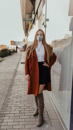 Full length portrait of young woman standing outdoors