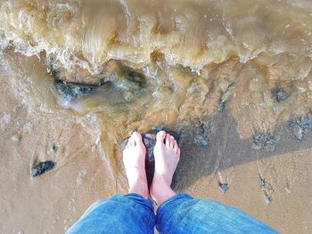 Low section of person standing on beach