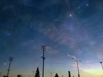 Low angle view of silhouette electricity pylon against sky during sunset