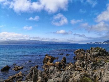 Scenic view of sea and mountains against sky