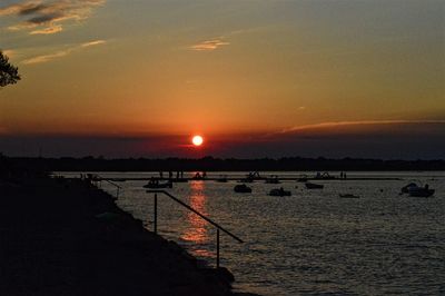 Silhouette of boat in sea during sunset