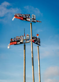 Low angle view of arrow sign against sky