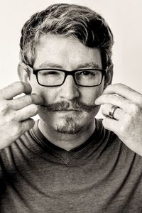 Portrait of man wearing eyeglasses against white background