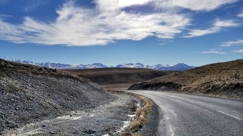 Road amidst land against sky