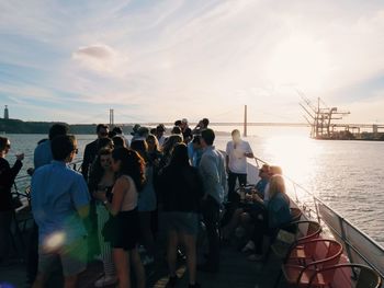 Group of people on boat in sea against sky