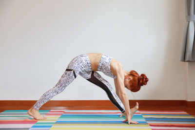 Young woman exercising on floor at home