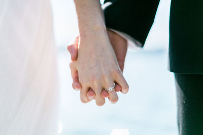 Midsection of couple holding hands