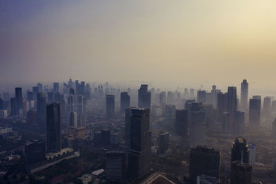 Aerial view of buildings in city against sky during sunset