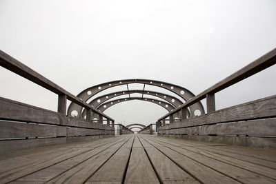 Surface level of footbridge against clear sky