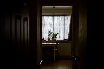 Woman looking through window at home