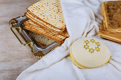 High angle view of matzo with religious cap and torah on table