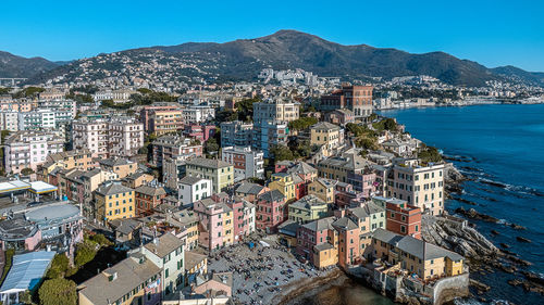 High angle view of buildings by sea against clear sky