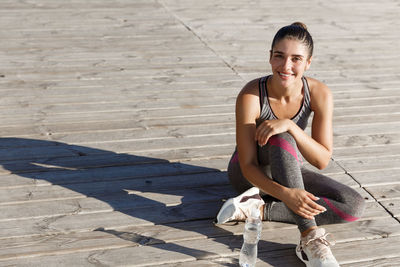 Portrait of smiling young woman sitting outdoors