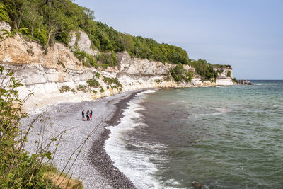 High angle view people at beach by rock formation